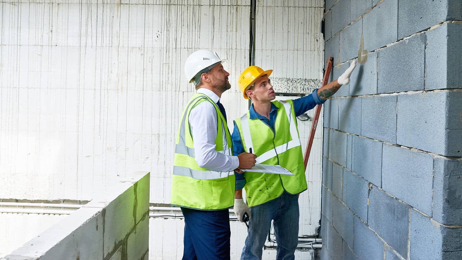 Two Workers Inspecting Wall