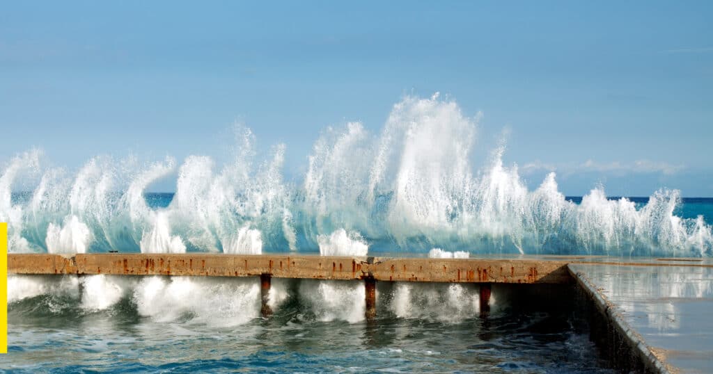 Manmade wood breakwater breaks waves as they come in from the ocean toward shore