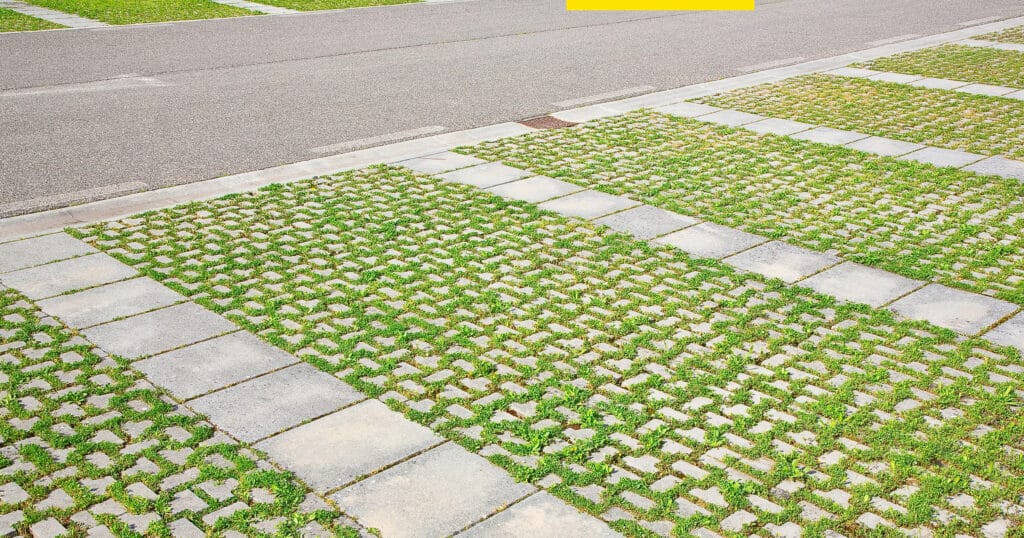 Permeable sidewalk next to street combines cement and patches of grass for stormwater absorption 